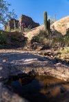 Mountain Biker Riding Steep Rock Roll Below Superstition Mountain Peaks.jpg