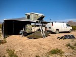 Van and offroad trailer with rooftop tent and awning deployed, camping in off-grid  desert environment.
