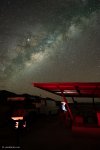 Cowboy checking a digital tablet at night under roadside shelter on Texas highway